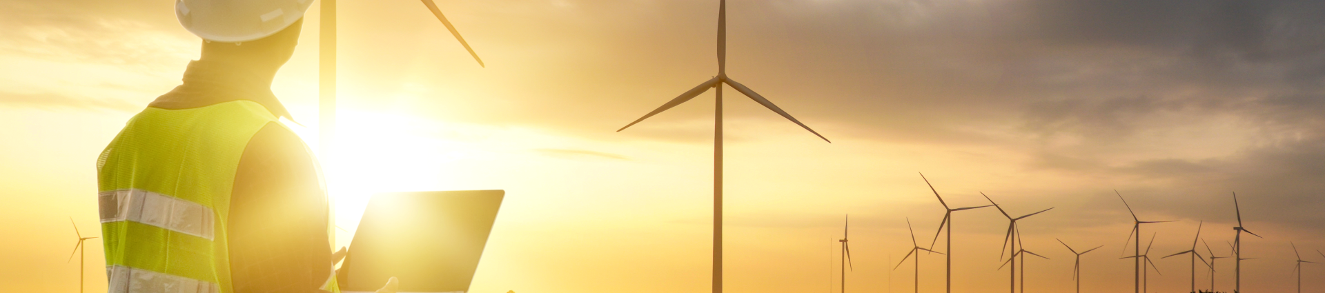 Wartungsarbeiter vor einem weit entfernten Windpark